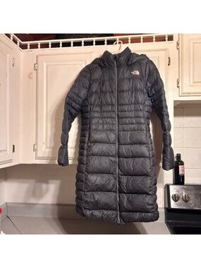 Warm and cozy long puffer jacket by The North Face. Ideal for winter adventures.